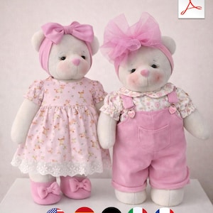 May include: Two white teddy bears wearing pink outfits. One bear is in a dress with a lace hem and matching shoes. The other bear is in pink overalls and a floral top, with a large pink bow. A PDF icon is in the top right corner.