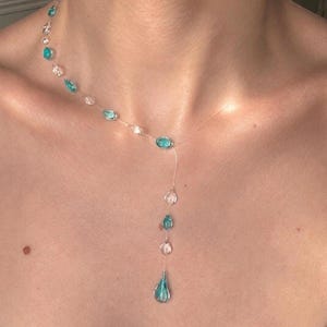 Turquoise glazen lariat-ketting in de vorm van een waterdruppel, asymmetrisch minimalistisch ontwerp met vloeibare details.
