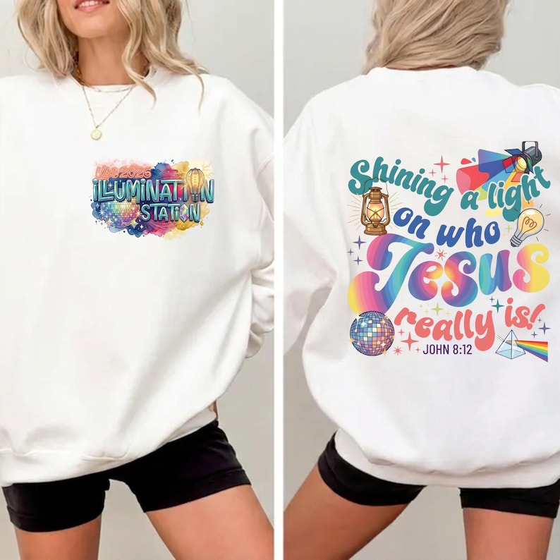 May include: White sweatshirt with the text "ILLUMINATION STATION" on the front, featuring a colorful design. The back of the sweatshirt has the text "Shining a light on who Jesus really is!" with additional graphics. A casual, comfortable style.