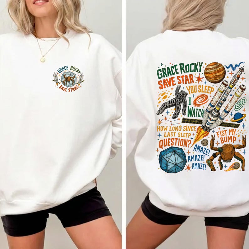 Op de afbeelding: Een wit sweatshirt met lange mouwen en een kleine afbeelding op de borst met de tekst "GRACE ROCKY SAVE STARS". De achterkant toont een grote ruimte-afbeelding met een raket, een planeet, een geometrische vorm en de tekst "GRACE ROCKY SAVE STAR YOU SLEEP I WATCH HOW LONG SINCE LAST SLEEP QUESTION? AMAZE! AMAZE! FIST MY BUMP".