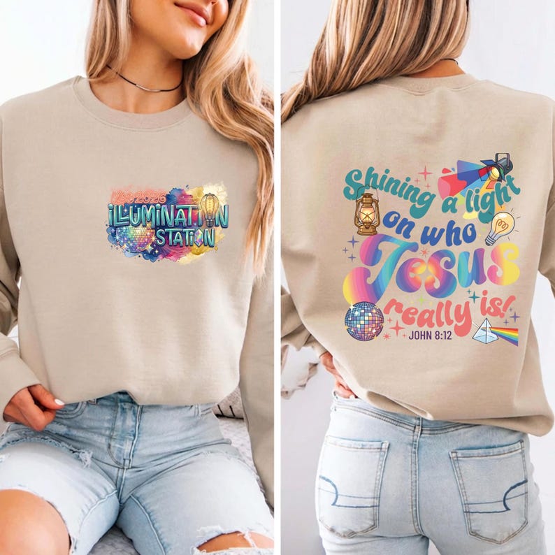 May include: Tan sweatshirt with colorful text and graphics. The front features "ILLUMINATION STATION" in a rainbow design. The back displays "Shining a light on who Jesus really is!" with a lantern, lightbulb, and disco ball.
