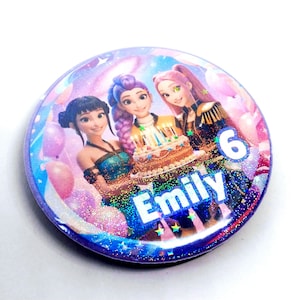 May include: A circular badge with a design of three cartoon girls and a birthday cake with candles. The name "Emily" and the number "6" are visible. The background has a galaxy theme with pink balloons and glitter.