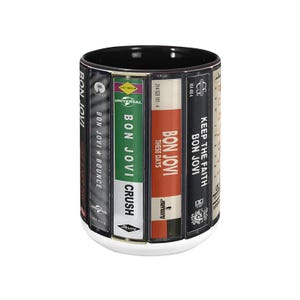 Pode incluir: Uma caneca de cer&acirc;mica branca com interior preto, apresentando capas de &aacute;lbuns do Bon Jovi, incluindo "Bounce", "Crush" e "These Days". A caneca tem uma base branca, exibindo um design tem&aacute;tico musical.