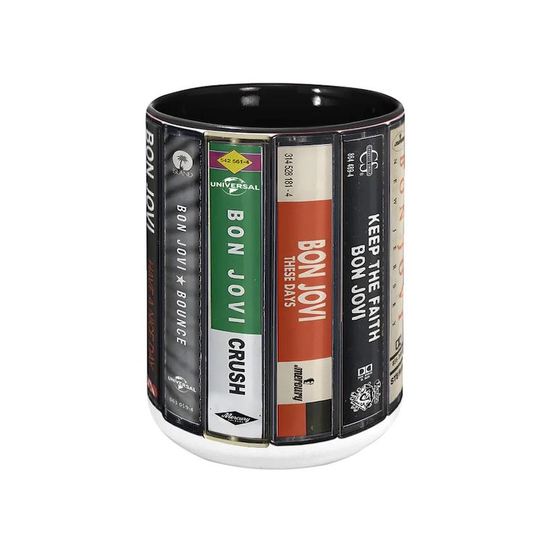 Pode incluir: Uma caneca de cer&acirc;mica branca com interior preto, apresentando capas de &aacute;lbuns do Bon Jovi, incluindo "Bounce", "Crush" e "These Days". A caneca tem uma base branca, exibindo um design tem&aacute;tico musical.