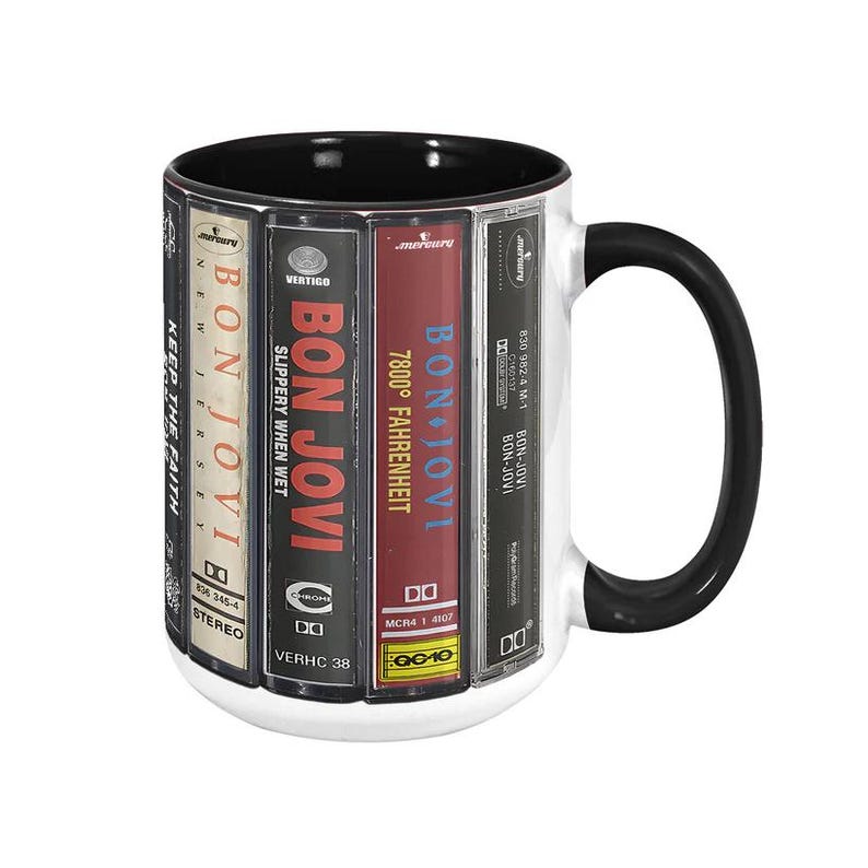 Pode incluir: Caneca de cer&acirc;mica branca com al&ccedil;a e interior pretos, apresentando arte de &aacute;lbuns do Bon Jovi. O design inclui t&iacute;tulos de &aacute;lbuns como "Slippery When Wet" e "7800&deg; Fahrenheit". Uma ideia de presente com tema musical.