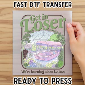 May include: A DTF transfer sheet featuring a graphic illustration of a pink boat on water inside a greenhouse. The text reads Get in Loser and We're learning about Lettuce. The design includes green foliage, purple and yellow flowers, and a geodesic dome.
