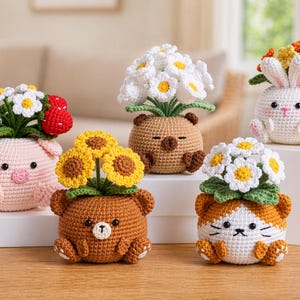 Peut inclure: Une collection de cinq pots de fleurs en crochet en forme d'animaux, chacun contenant un type de fleur différent. Les pots sont en forme de cochon, deux ours, un chat et un lapin. Les fleurs comprennent des marguerites, des tournesols et d'autres fleurs colorées.