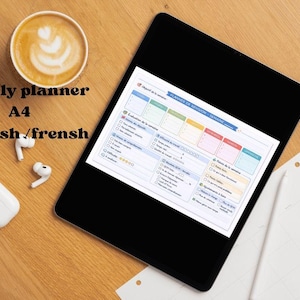 Peut inclure: Un planificateur hebdomadaire numérique sur une tablette, avec une tasse de café et des écouteurs sans fil. Le planificateur est en anglais et en français. Le texte sur l'image dit "weekly planner A4 english / frensh".