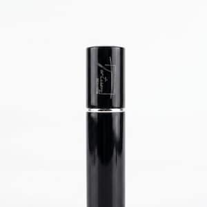 May include: A black cylindrical perfume bottle with a silver band. The top section has the text "artlesso" in a stylized font. The bottle is set against a white background.