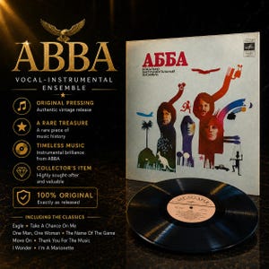 Op de afbeelding: Een ABBA vinylplaat album met de bandnaam in gouden letters en een vintage albumhoes met illustraties. Het album bevat klassieke nummers als "Take a Chance on Me" en "The Name of the Game."