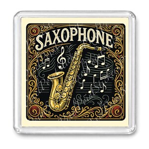 May include: A square magnet featuring a gold saxophone illustration with musical notes on a black background. The word "SAXOPHONE" is written in white script above the instrument, with decorative gold filigree.