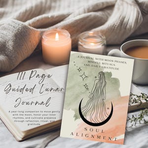 May include: A guided lunar journal with the text "Soul Alignment" and "A journal with moon phases, mindful rituals, and daily gratitude." The image includes a lit candle, a cup of coffee, and an open book.