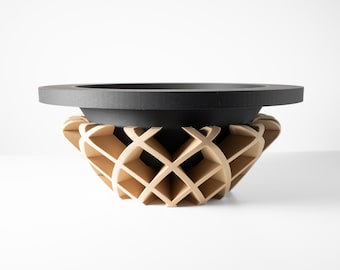 Puede incluir: Un cuenco decorativo con borde negro y base de patrón de celosía marrón claro. El cuenco tiene un diseño moderno y probablemente está hecho de madera o un material similar. El cuenco está sobre una superficie blanca.