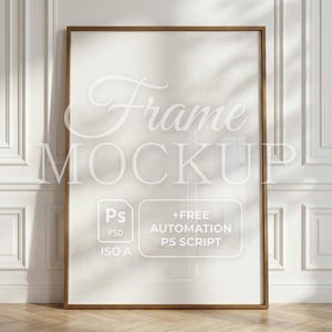 Puede incluir: Una maqueta de marco rectangular con un marco de madera marrón, apoyada contra una pared blanca con molduras decorativas. El marco tiene el texto "Frame Mockup" y un gráfico con "Ps PSD ISO A" y "+FREE AUTOMATION PS SCRIPT".