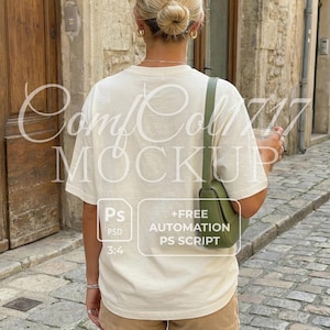 Peut inclure: Maquette de t-shirt crème avec le texte "ComfCol 717 MOCKUP" et un graphique avec "Ps PSD 3:4 +FREE AUTOMATION PS SCRIPT". Le modèle porte un short en velours côtelé et un sac vert. L'arrière-plan est une rue pavée.