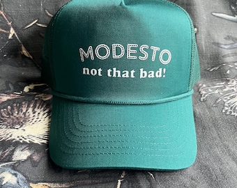 Op de afbeelding: Een witte keramische mok met een zwarte handgreep en de tekst "But First, Coffee" in een vetgedrukte, zwarte letter. De mok staat tegen een effen witte achtergrond, wat het eenvoudige ontwerp benadrukt.