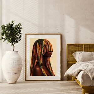 K&ouml;nnte beinhalten: Ein gerahmter Kunstdruck mit dem Profil einer Person mit bunten, perlenbesetzten Haaren. Das Kunstwerk befindet sich in einem Holzrahmen und wird in einem Schlafzimmer ausgestellt. Die Farbpalette umfasst Braunt&ouml;ne, Gelb, Gr&uuml;n und Rot.