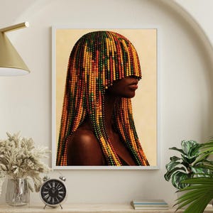 K&ouml;nnte beinhalten: Ein gerahmter Kunstdruck mit einem Seitenprofil einer Person mit dunkler Haut. Das Haar der Person ist mit farbigen Perlen in Gelb-, Orange-, Rot- und Gr&uuml;nt&ouml;nen gestaltet. Das Kunstwerk wird auf einem Regal mit einer Uhr und dekorativen Gegenst&auml;nden ausgestellt.