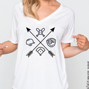May include: White v-neck t-shirt with a black baseball-themed graphic. The graphic features crossed arrows with a baseball bat and ball, a baseball glove, a baseball cap, and a home plate.