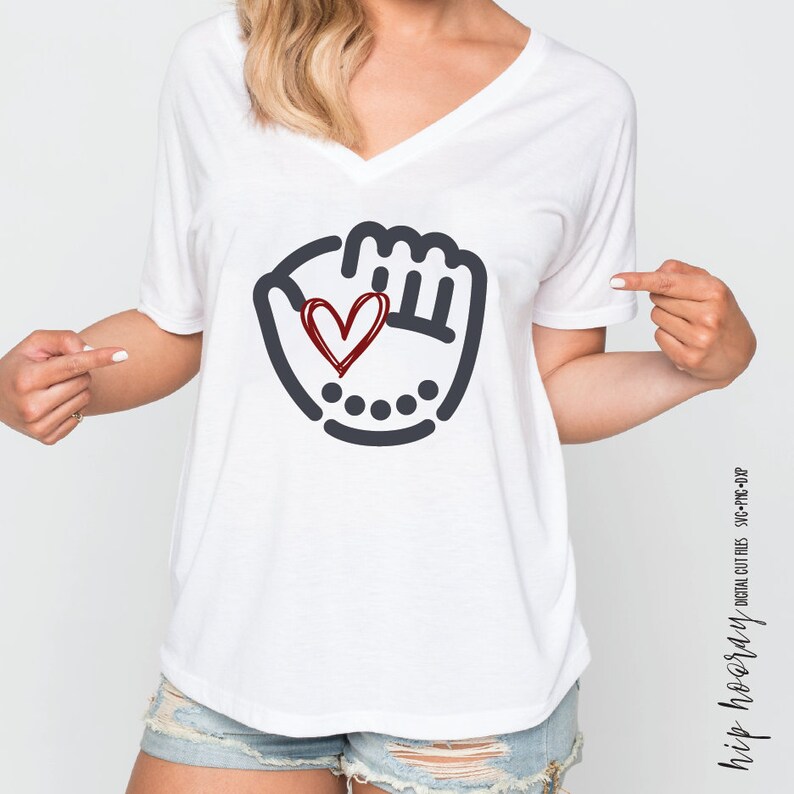 K&ouml;nnte beinhalten: Wei&szlig;es T-Shirt mit V-Ausschnitt und einem schwarzen und roten Grafikdruck eines Baseballhandschuhs mit einem Herzen darin. Die Grafik ist im einfachen Strichzeichnungsstil gehalten.