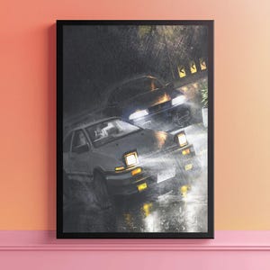 Può includere: Opera d'arte incorniciata raffigurante due auto da corsa sotto la pioggia. L'auto in testa è una sportiva bianca e nera con i fari accesi, e la seconda auto è di colore scuro. L'opera d'arte ha un'estetica cupa e malinconica.