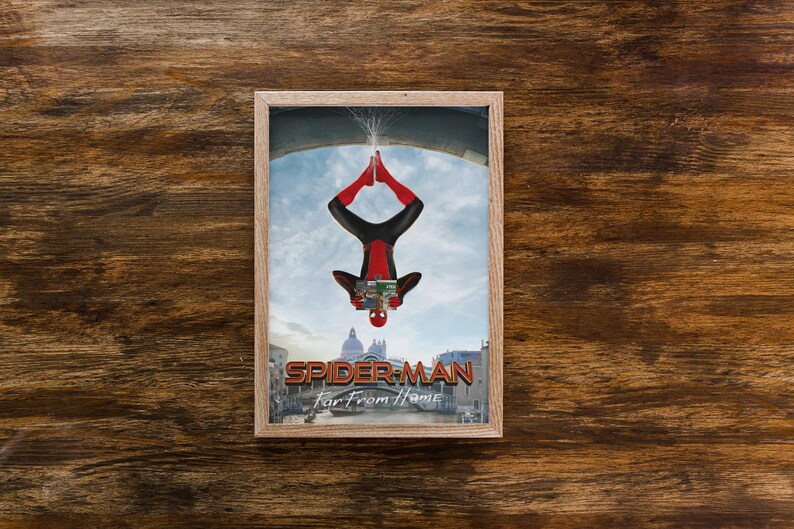 May include: Framed print featuring Spider-Man in a red and black suit, hanging upside down. The image includes the text "SPIDER-MAN Far From Home" and a cityscape background. The frame is a light brown color.