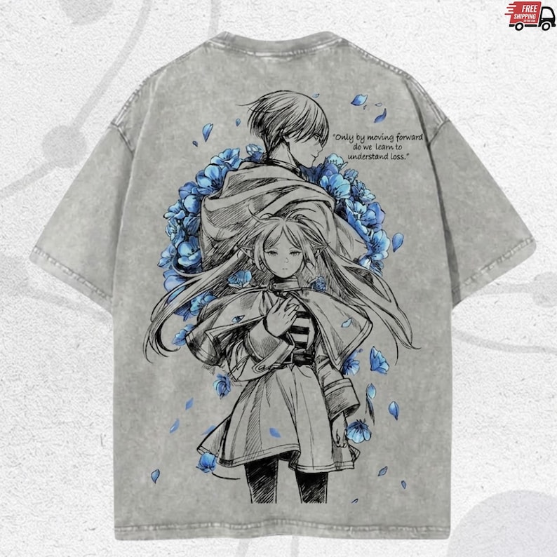 Puede incluir: Camiseta gris con una ilustraci&oacute;n de estilo anime de dos figuras y flores azules. La parte trasera de la camiseta incluye la cita: "S&oacute;lo avanzando aprendemos a entender la p&eacute;rdida."