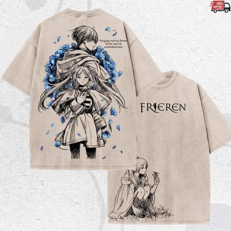 Puede incluir: Camiseta beige con ilustraciones estilo anime en la parte delantera y trasera. La parte delantera presenta dos figuras rodeadas de flores azules, con texto. La parte trasera muestra la palabra "FRIEREN" en negro.