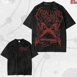 Puede incluir: Dos camisetas negras con lavado ácido y diseños gráficos rojos. Una camiseta presenta el texto "IRON LUNG" y una ilustración de monstruo en la espalda. La otra tiene el mismo texto en la parte delantera. Ambas tienen mangas cortas y cuello redondo.