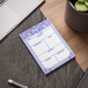 May include: A lavender study notes pad with floral accents and the words "Study Notes" in script. The pad has sections for topic, date, Bible verse, notes, observation, application, and prayer. A pen and laptop are in the background.