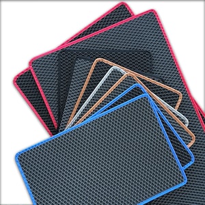 May include: A collection of rectangular mats with a textured, diamond-patterned surface. Each mat has a colored border, including red, black, white, brown, and blue. The mats are arranged in a fan shape, showcasing the variety of colors.