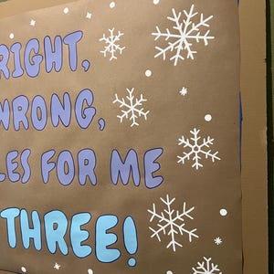 Puede incluir: Un cartel marr&oacute;n con las palabras "RIGHT, WRONG, RULES FOR ME, THREE!" en azul y blanco. Copos de nieve y puntos blancos est&aacute;n dispersos por el cartel. El cartel est&aacute; montado sobre cart&oacute;n.