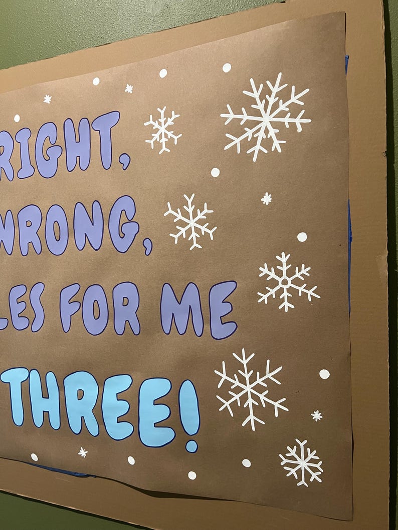 Puede incluir: Un cartel marr&oacute;n con las palabras "RIGHT, WRONG, RULES FOR ME, THREE!" en azul y blanco. Copos de nieve y puntos blancos est&aacute;n dispersos por el cartel. El cartel est&aacute; montado sobre cart&oacute;n.