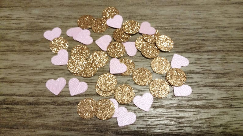 May include: Pink and gold confetti hearts. The hearts are made of paper and have a glitter finish.