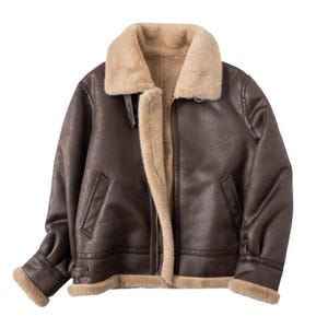 Könnte beinhalten: Braune Lederjacke mit beigem Kunstfellkragen und Futter. Die Jacke hat einen Reißverschluss vorne, zwei Vordertaschen und eine Schnalle am Kragen. Die Ärmel haben einen Kunstfellbesatz.