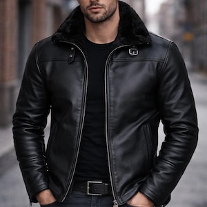 May include: A black leather jacket with a faux fur collar, zip fastening, and a belt. The jacket is worn with a black top and dark wash jeans. The person is standing with their hands in their pockets.