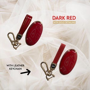 May include: Dark red key fob with gold detailing and a matching leather keychain. The key fob has gold trim and is shown with a gold-coloured clasp. The text "Dark Red with Gold Detailing" is in the image.