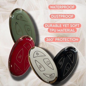 May include: Four car key fobs in green, red, white, and black, each with a gold trim. The fobs have white icons for lock, unlock, and hold functions. Text on the image reads "Waterproof", "Dustproof", "Durable Yet Soft TPU Material", and "360&deg; Protection".