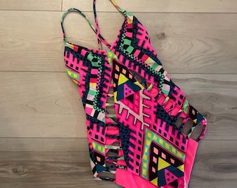 Gorgeous one piece swim suit. Bright and cut outs  in the flattering areas