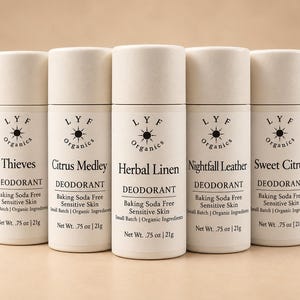 May include: Five cylindrical deodorant sticks with off-white labels and caps. Each label features the LYF Organics logo, scent names including Thieves, Citrus Medley, Herbal Linen, Nightfall Leather, and Sweet Citrus, and states Net Wt. .75 oz | 21g.