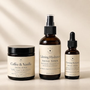 May include: Three amber glass skincare containers with cream labels. A 4 oz jar of Coffee & Vanilla Facial Scrub, a 4 fl oz spray bottle of Calming Hydration Facial Toner with Niacinamide, and a 1 fl oz dropper bottle of Firming Renewal Facial Serum.