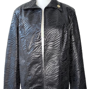 May include: Black jacket with a zebra stripe pattern. The jacket has a collar and a single button closure. The fabric has a shiny finish. The jacket is displayed on a white mannequin.
