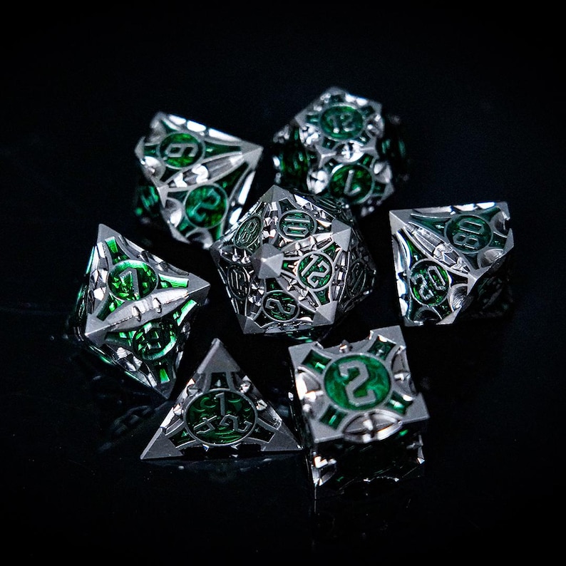 May include: Set of seven metallic dice with a silver finish and green accents. Each die features intricate geometric designs and visible numbers. The dice are arranged on a dark surface, highlighting their reflective qualities. Ideal for tabletop gaming.
