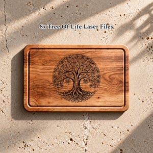 May include: A rectangular wooden cutting board featuring a laser-engraved Tree of Life design in the center. The board has a grooved border and a natural wood grain finish. The text 8x Tree Of Life Laser Files is visible above the board.