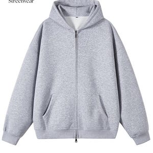 以下が含まれることがあります： フードとフロントポケットが付いた、ライトグレーのジップアップパーカー。 パーカーはフルレングスのジッパーとリブ編みの袖口と裾が付いています。 テキスト「CC Streetwear」が左上にあります。