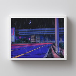 May include: A framed print featuring a nighttime cityscape with a highway and rain. The artwork has a blue and purple color scheme with red streaks of light from passing vehicles. A crescent moon is visible in the dark sky.