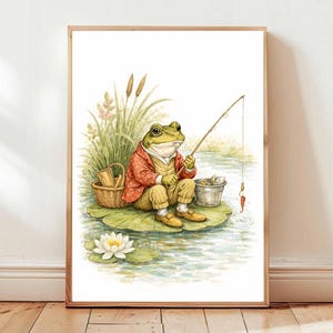 May include: Watercolor print of a frog dressed in a red jacket and yellow pants, fishing from a lily pad. The frog is holding a fishing rod, with a bucket and basket nearby. The artwork is framed in a wooden frame.
