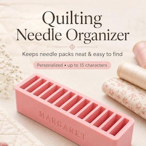 Puede incluir: Un organizador de agujas de acolchado rectangular de color rosa con diez ranuras verticales y el nombre MARGARET grabado en el frente. El texto Quilting Needle Organizer, Keeps needle packs neat & easy to find y Personalized up to 15 characters es visible.