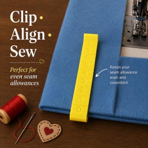 Peut inclure: Un guide de couture en plastique jaune vif avec des chiffres en relief de zéro à huit, posé sur un tissu bleu. Le texte indique Clip Align Sew. Une bobine de fil rouge, une aiguille et un écusson en forme de cœur sont présents à côté.