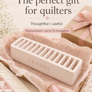Pu&ograve; includere: Un organizer rettangolare rosa chiaro con dieci fessure verticali per rocchetti, con la parola GRAMMY incisa sulla parte anteriore. Il testo sull'immagine recita: The perfect gift for quilters, Thoughtful + useful, Personalized &bull; up to 15 characters.